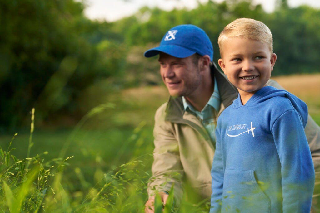 man wearing blue cirrus hat and little boy wearing blue Cirrus sweatshirt 