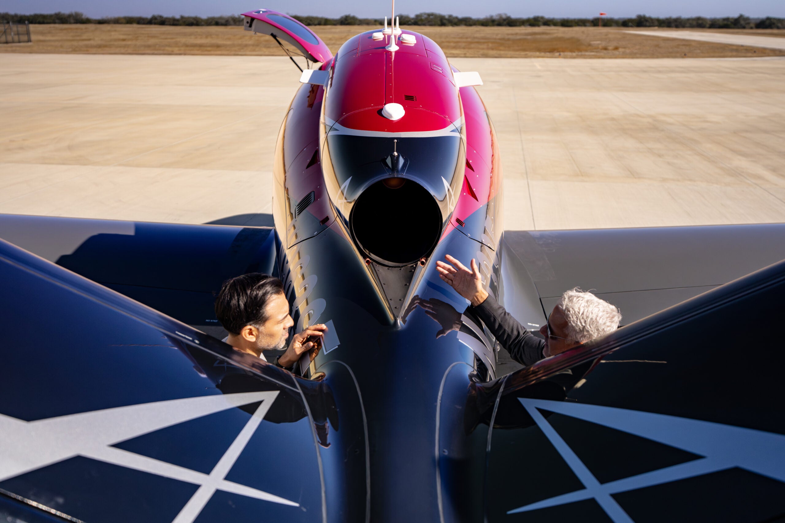 people looking at engine of Vision Jet