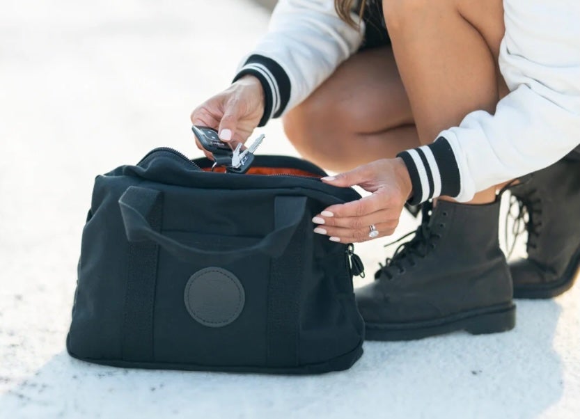 women grabbing her keys from cirrus parachute bag