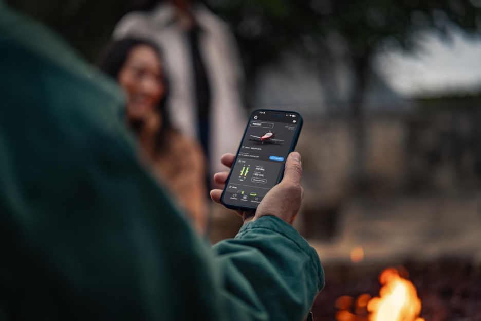 man holding phone with IQ app open to jet dashboard