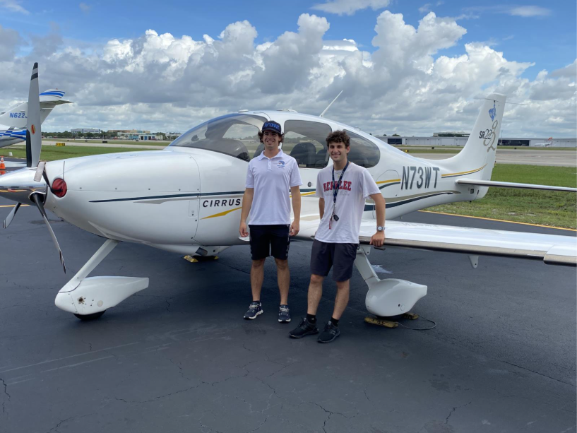 flight students sanding in front of Cirrus 