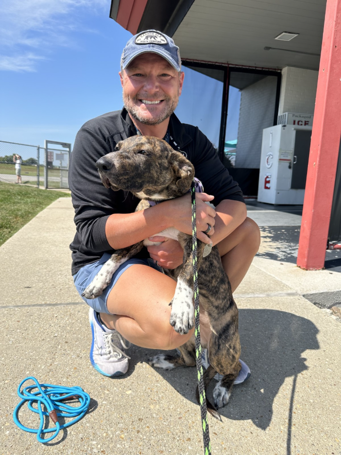 man hugging dog at airport