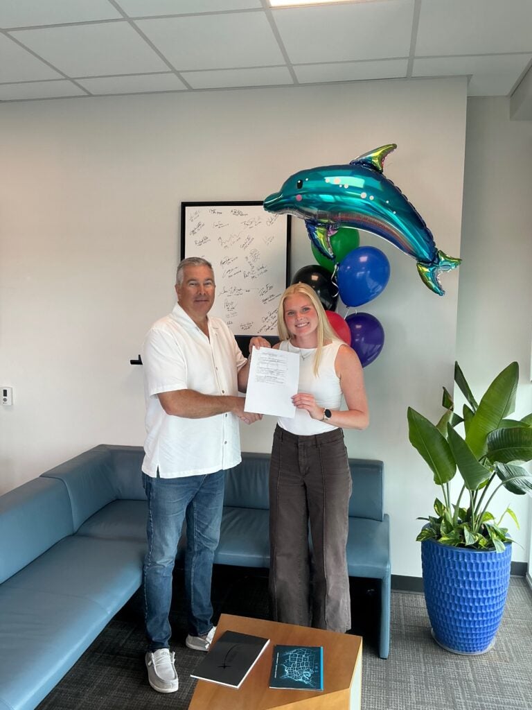 man and women shaking hands and holding checkride certificate 