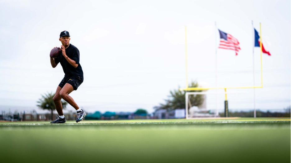 Josh Dobbs training with a football on a field beside U.S. and Texas flags