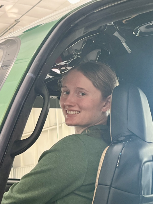 Maddie Allen seated in the left seat of a Cirrus Vision Jet, looking back over her shoulder