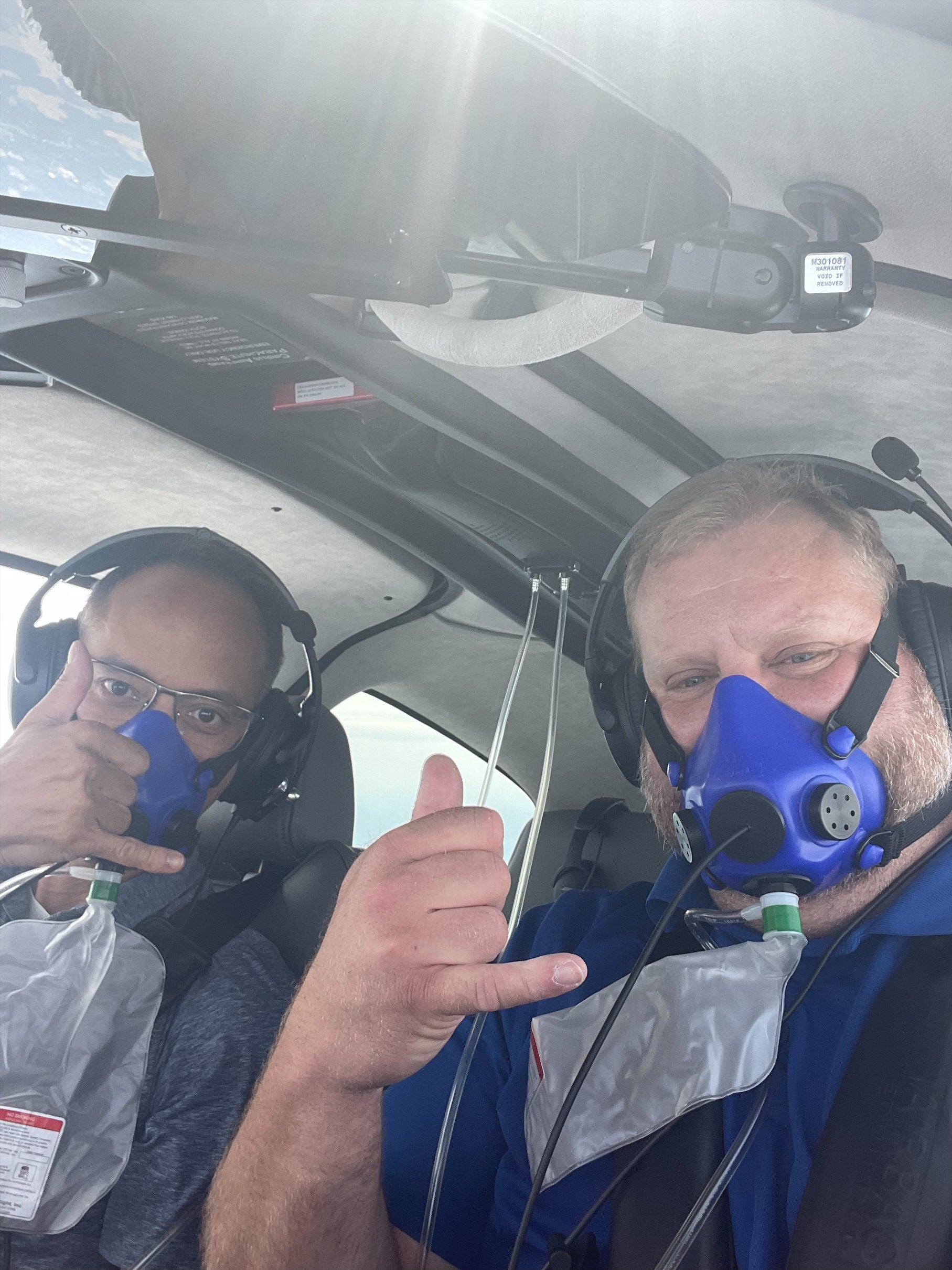 John Hutchings and a passenger wearing oxygen masks in his SR Series aircraft.