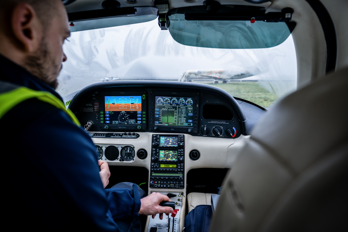Technician running checks in the cockpit of a Cirrus SR Series aircraft