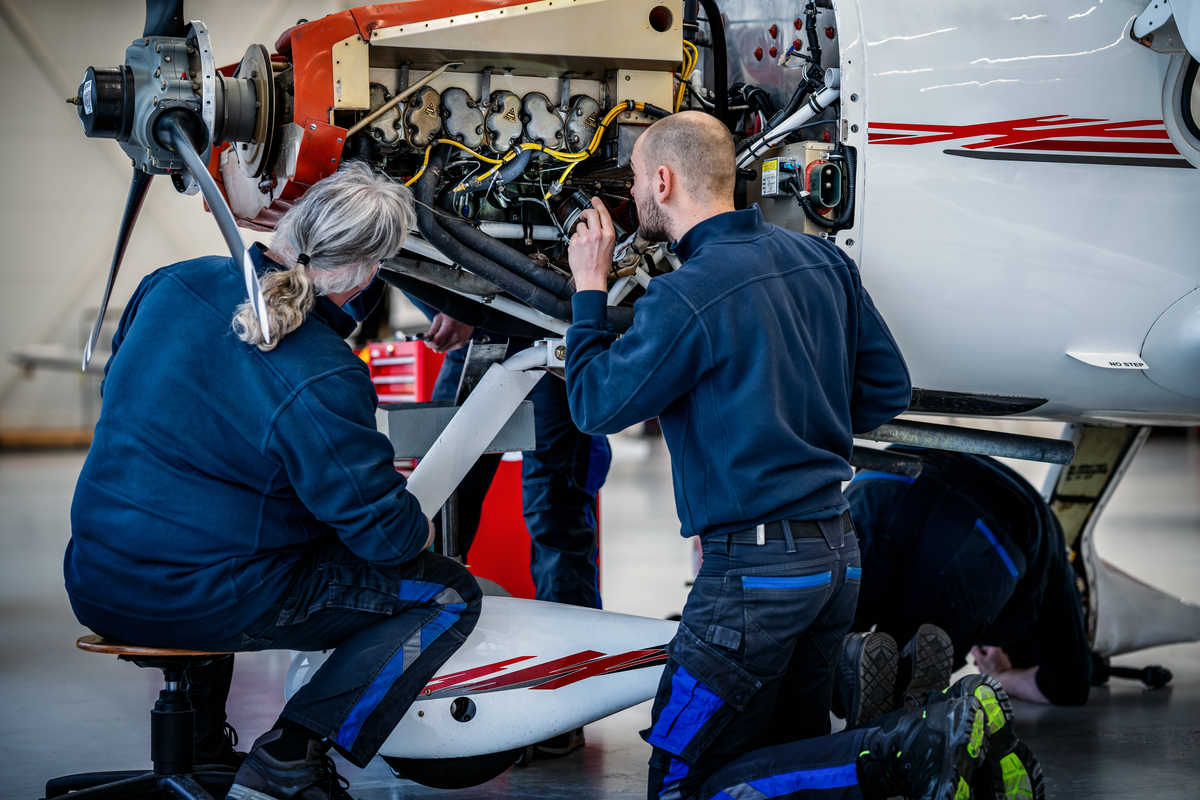 Cirrus technicians working on the engine of a Cirrus SR Series aircraft