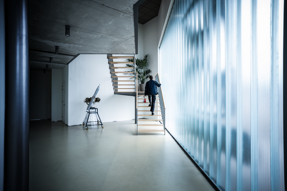 Interior of the Cirrus Netherlands facility with a staircase and frosted glass wall