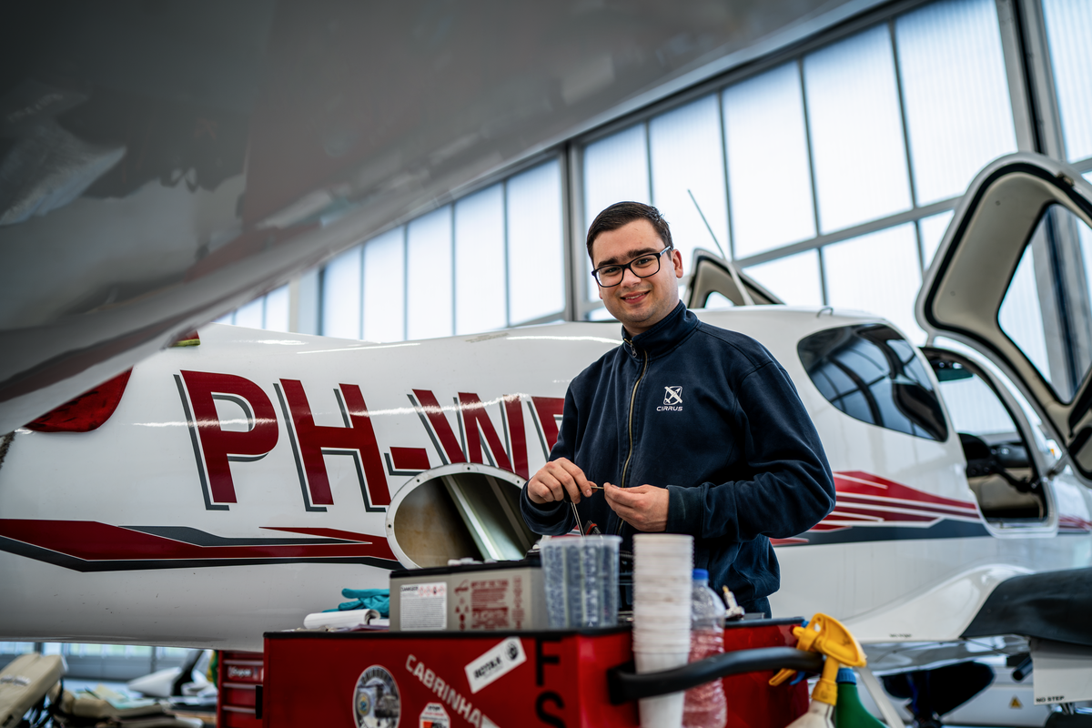Cirrus technician preparing cleaning products beside a Cirrus SR Series aircraft