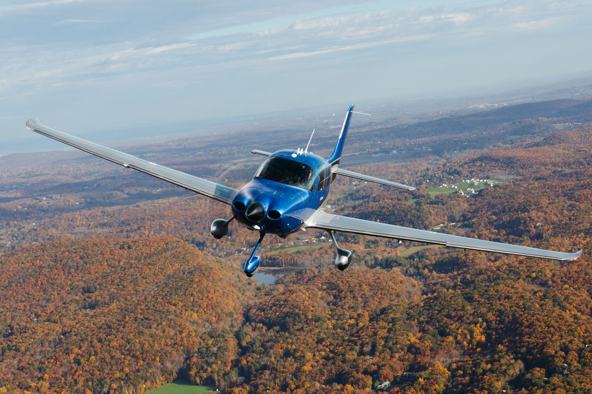 cirrus sr Gy flying over fall trees